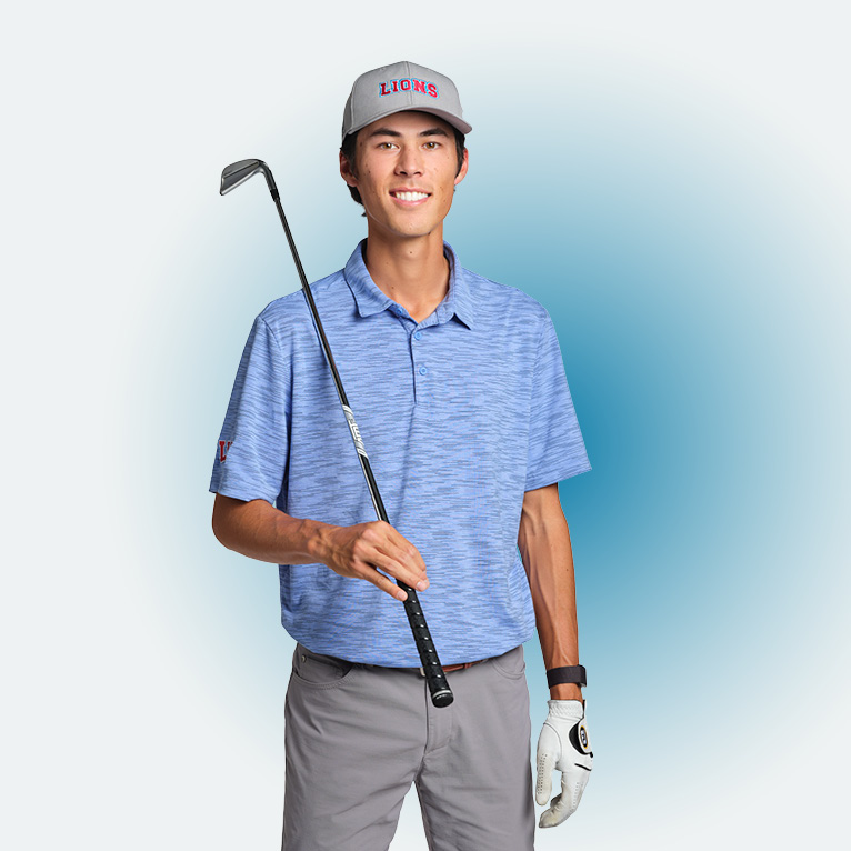 Cropped portrait of LMU business major Riley Lewis in a Lions ballcap, blue polo, holding a golf club in his right hand against his shoulder, with a golf glove on his left hand, on a white background