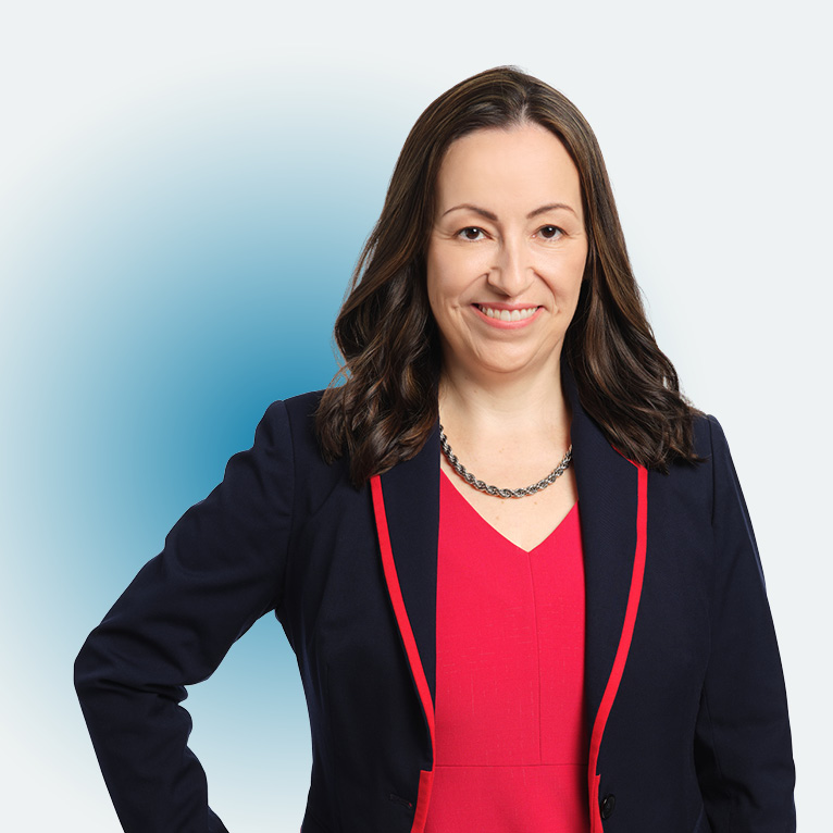 Close-up portrait of LMU provost for LMU Global-Local Affairs, Roberta Espinoza, in a black suit with red accents, smiling at the camera, on a white background.