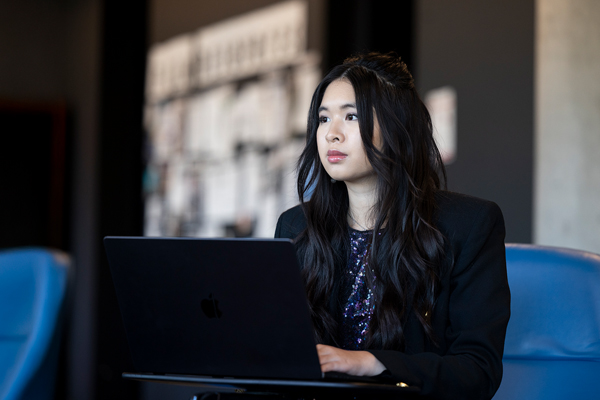 An LMU graduate student sitting in front of a computer.